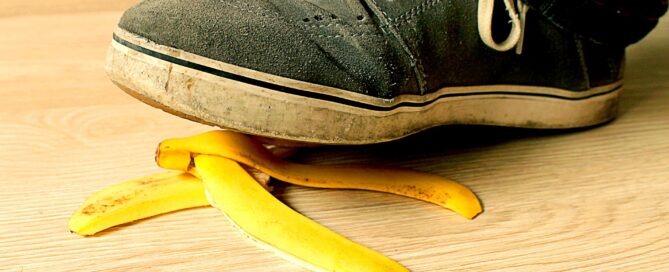 Shoe nearly stepping on peeled banana