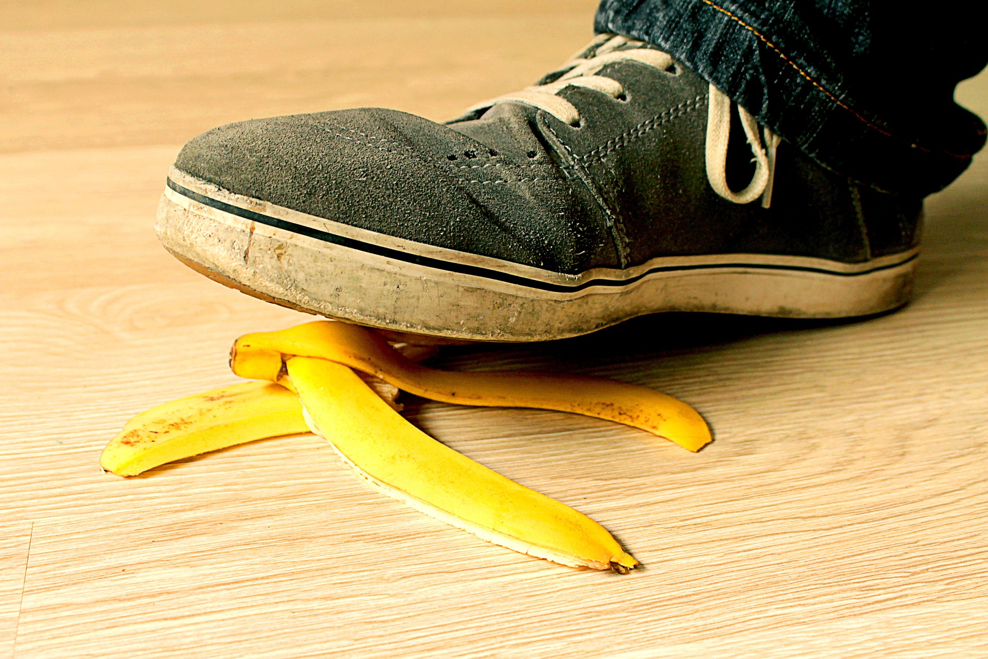 Shoe nearly stepping on peeled banana