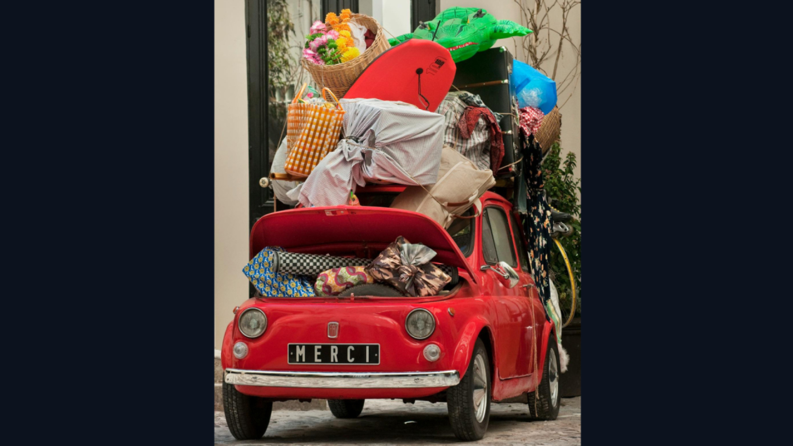 Red car overfilled with items.