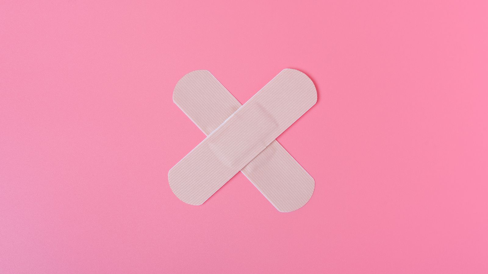 Pink background with two plasters in the middle crossing over each other. White SARD logo top right.