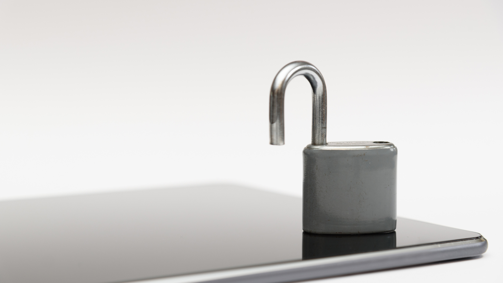 Unlocked lock on grey background